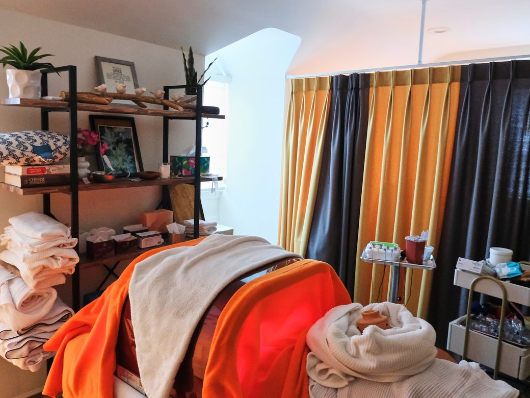 A treatment room prepared with a draped table and therapy equipment