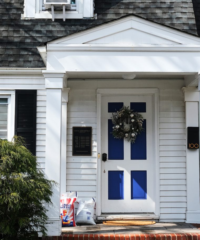 The blue front door of the clinic beneath a white portico